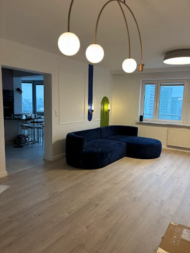 Salon Premium - Stylowy salon premium z granatową sofą, eleganckim stołem jadalnianym i nastrojowym oświetleniem | PROFESA BUD - Remonty i wykończenia wnętrz Warszawa